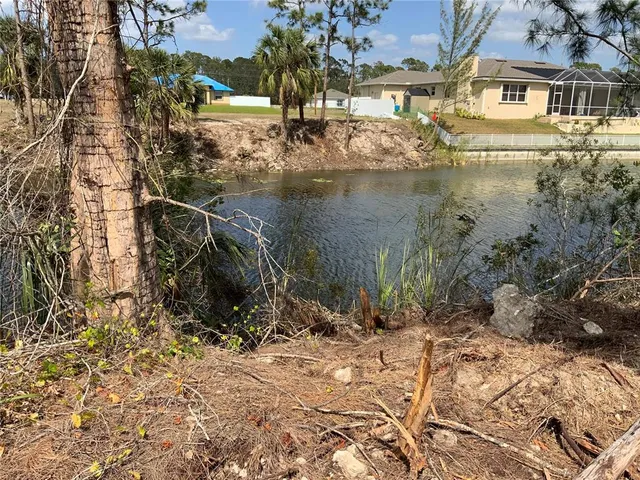 a view of water pond with lots of trees and buildings