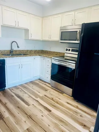 a kitchen with granite countertop a stove microwave and sink