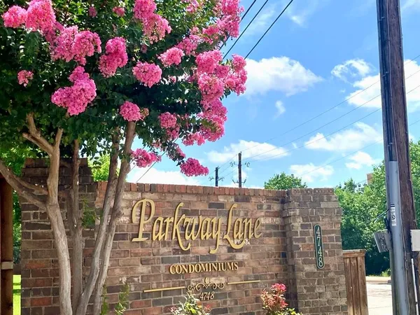 a street sign that is sitting in front of flowers