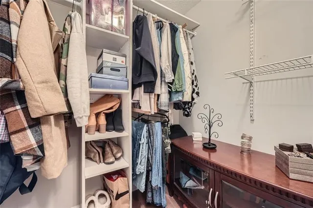 a view of walk in closet with clothes and shoes