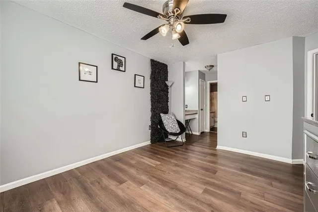 a view of a room with wooden floor and ceiling fan
