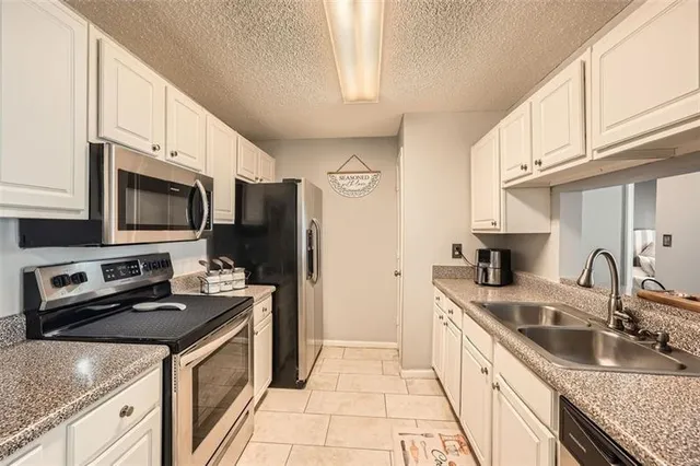 a kitchen with granite countertop a sink stove and refrigerator