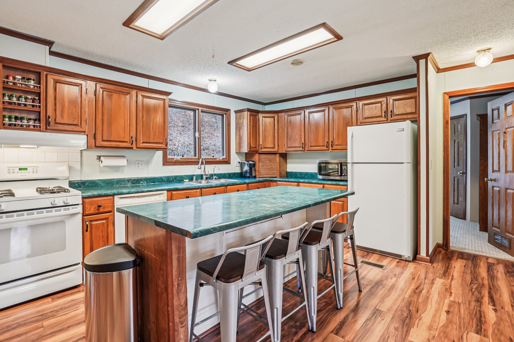 3668 Old Sams Creek Road Pegram, TN 37143 - Photo 15 of 60 a kitchen with stainless steel appliances granite countertop a refrigerator a sink dishwasher a stove and white countertops with wooden floor