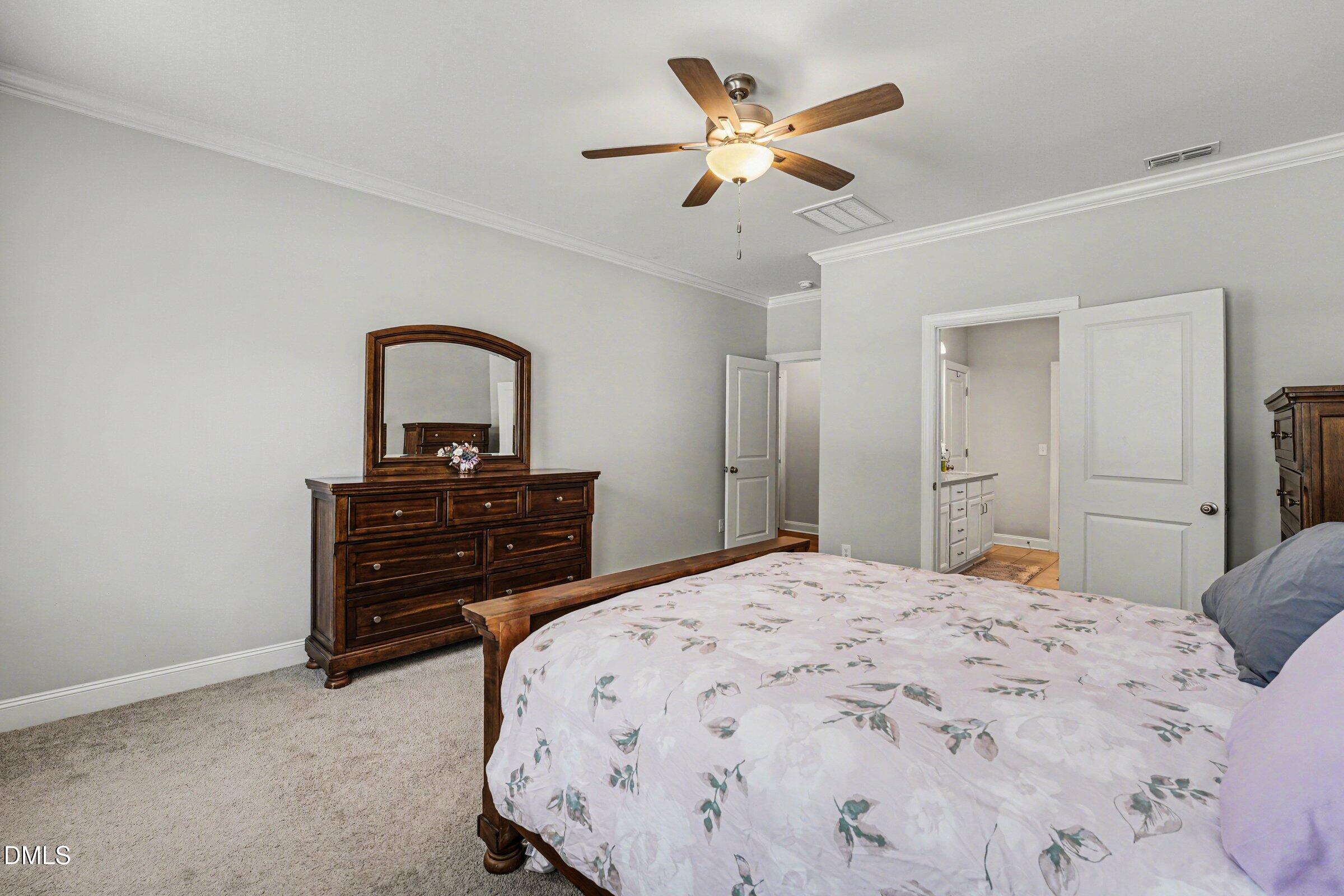 130 Aylebury Ridge Zebulon, NC 27597 - Photo 19 of 41 a bedroom with a bed and a chandelier