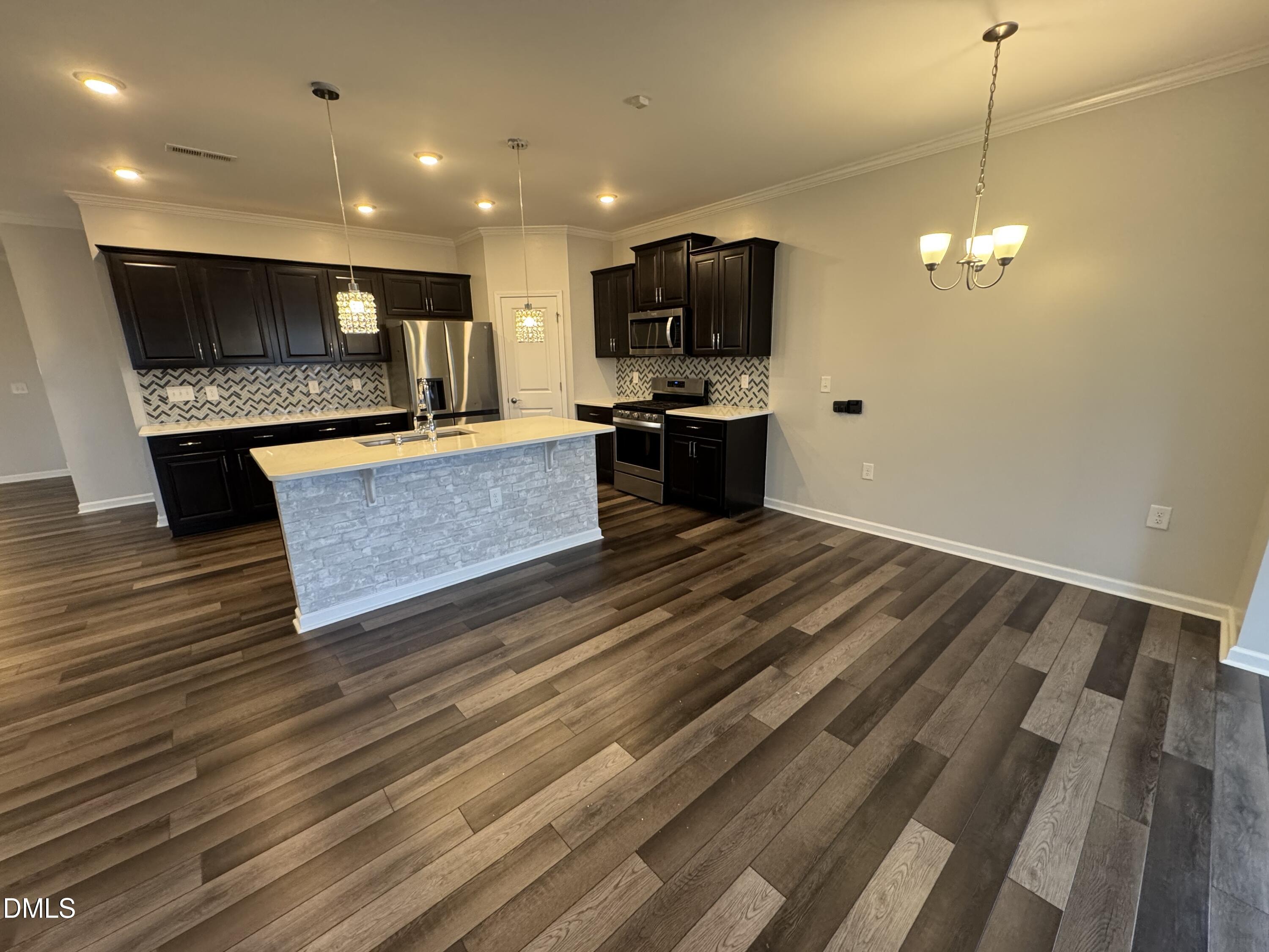 2022 Attend Crossing Fuquay-Varina, NC 27526 - Photo 12 of 43 a view of kitchen with refrigerator stove microwave and wooden floor