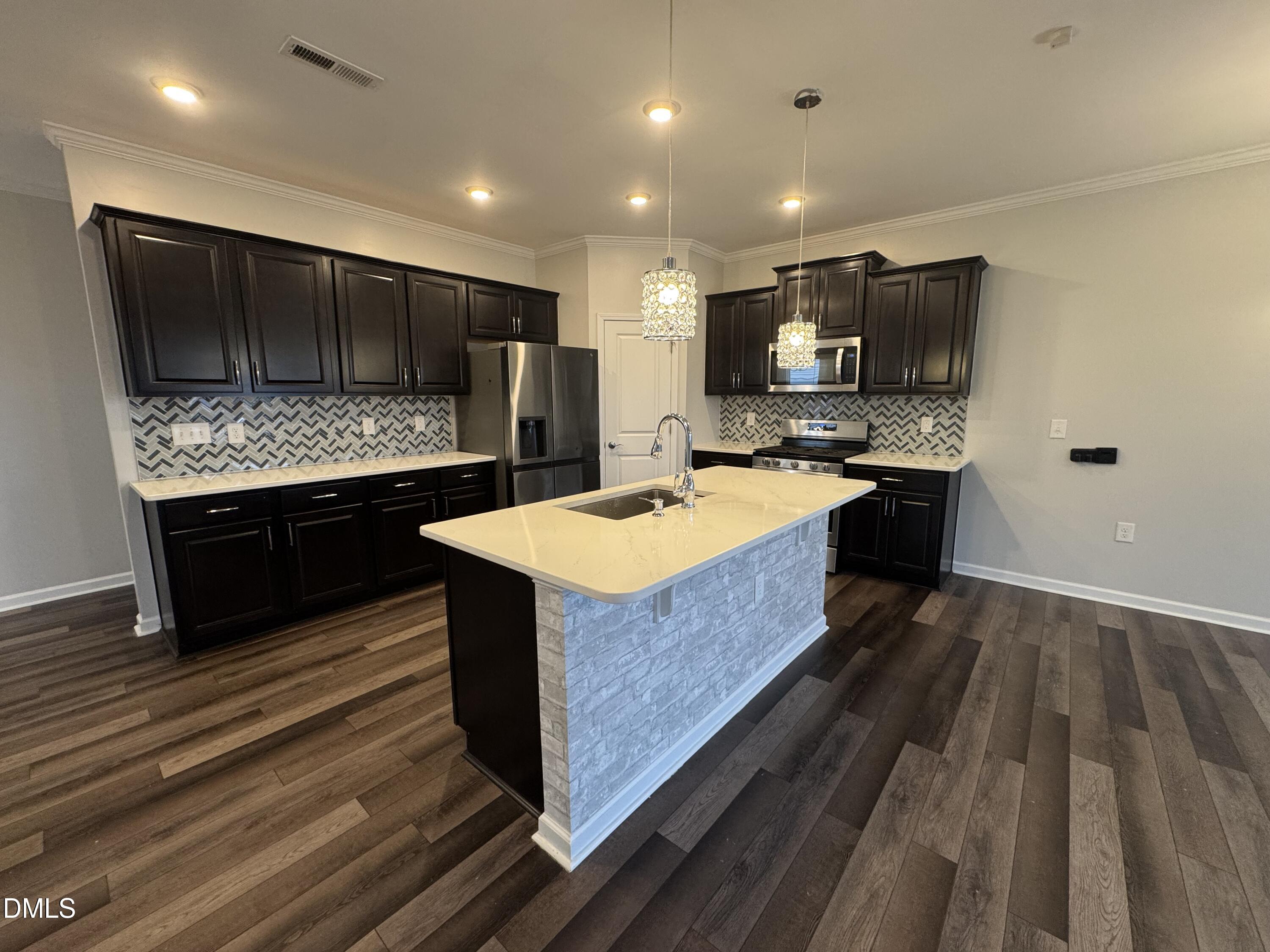 2022 Attend Crossing Fuquay-Varina, NC 27526 - Photo 13 of 43 a kitchen with kitchen island a sink stove and wooden floor