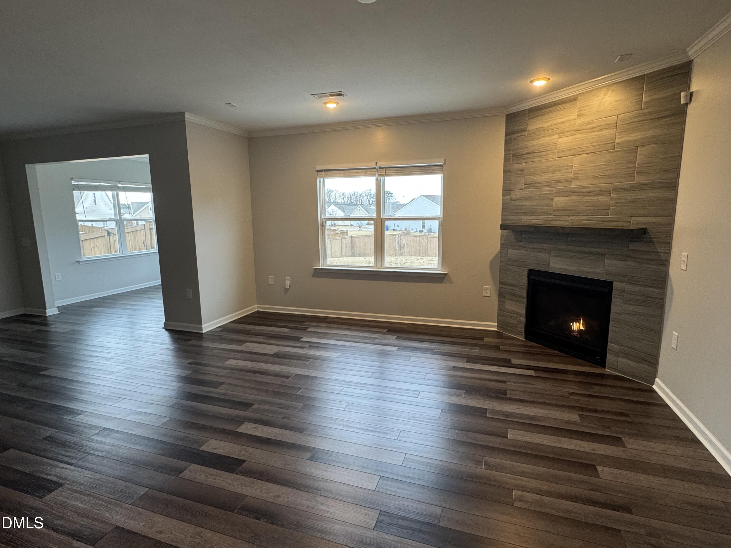 2022 Attend Crossing Fuquay-Varina, NC 27526 - Photo 16 of 43 an empty room with wooden floor fireplace and windows