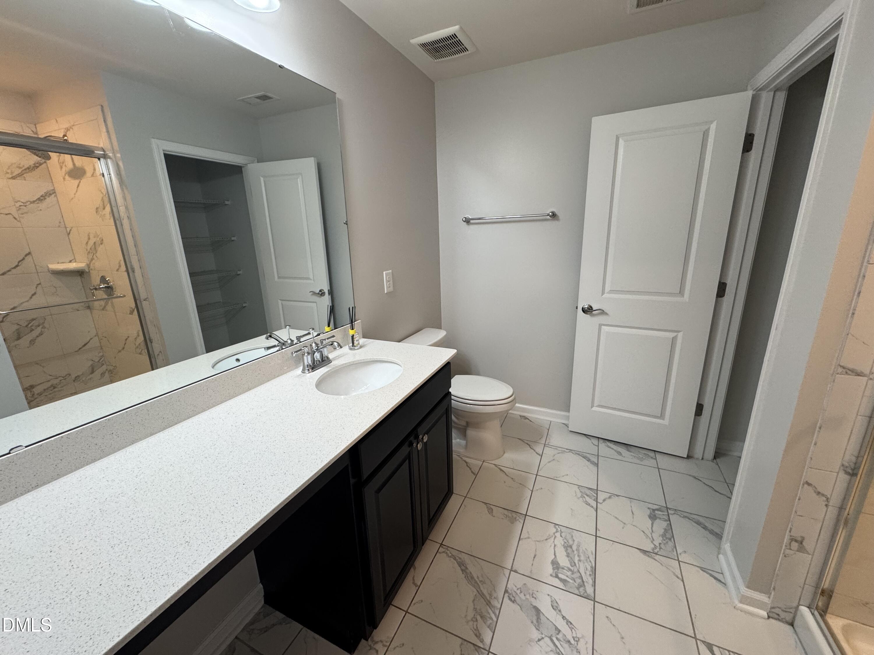 2022 Attend Crossing Fuquay-Varina, NC 27526 - Photo 23 of 43 a bathroom with a sink a toilet a mirror and vanity