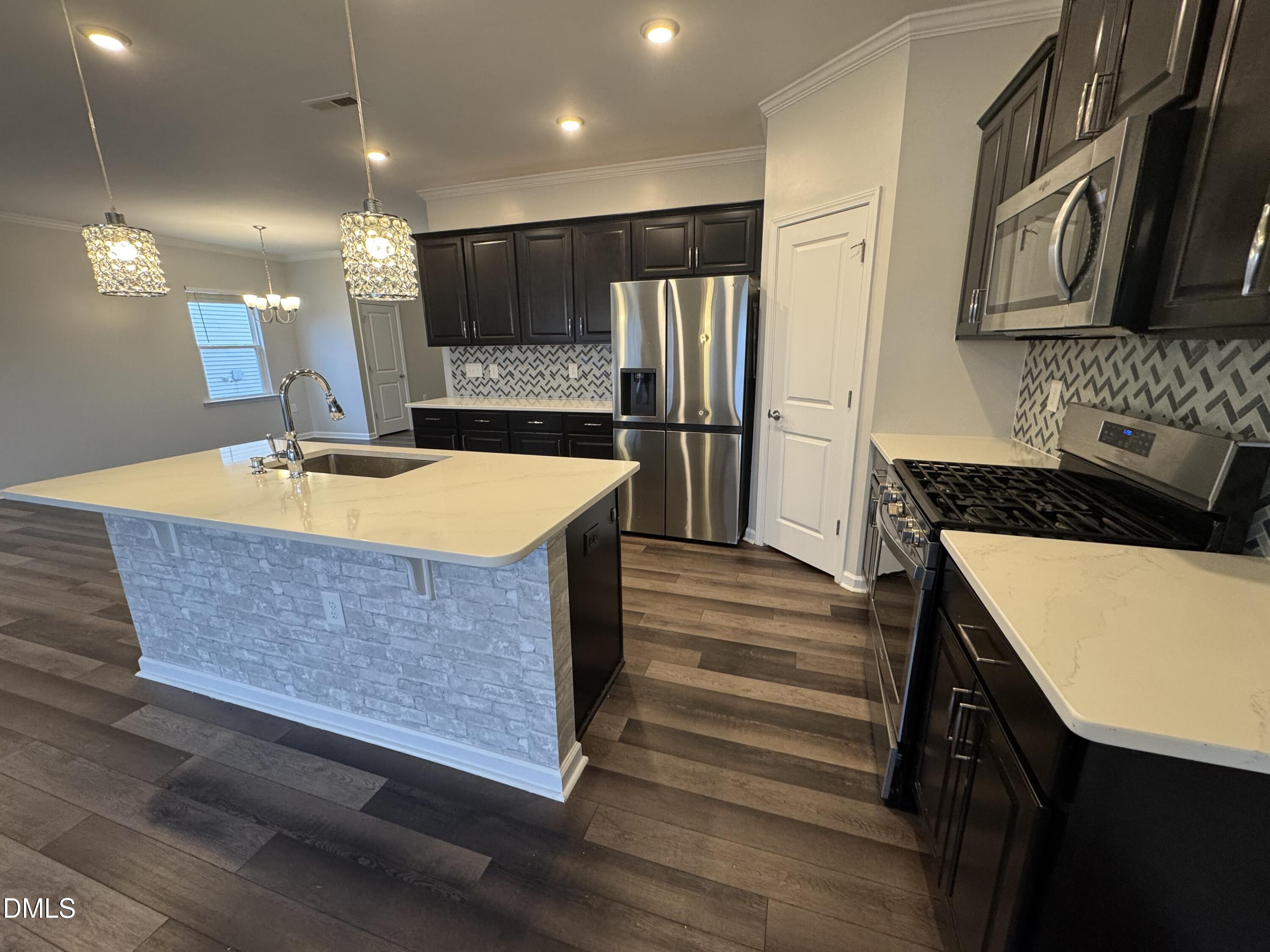 2022 Attend Crossing Fuquay-Varina, NC 27526 - Photo 5 of 43 a kitchen with stainless steel appliances granite countertop a sink dishwasher a stove and a refrigerator with wooden floor