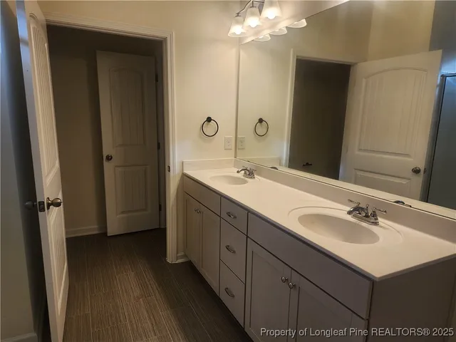 a bathroom with a double vanity sink mirror and shower