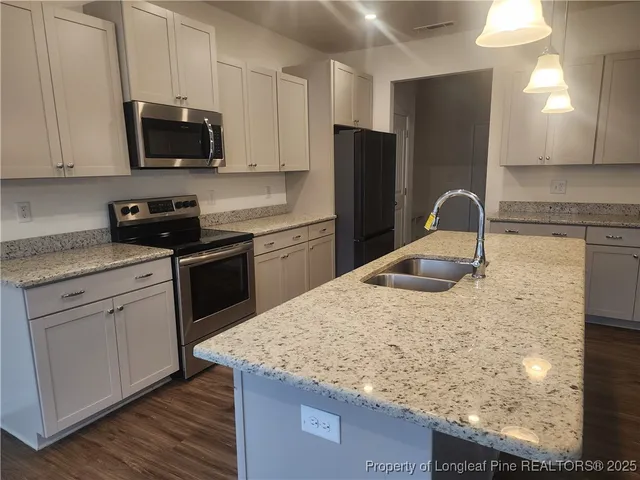 a kitchen with stainless steel appliances granite countertop a sink stove and refrigerator