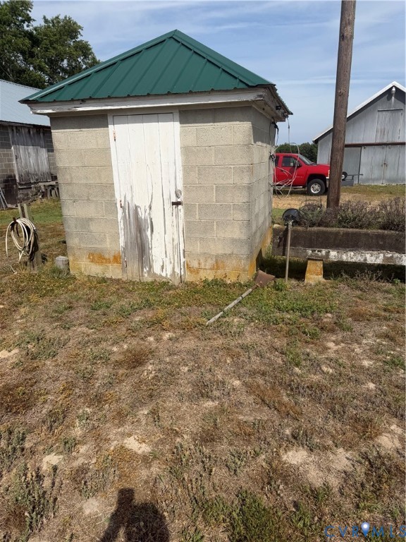9380 Wakefield Road Wakefield, VA 23888 - Photo 4 of 11 Cinder block outbuilding featuring a green metal r