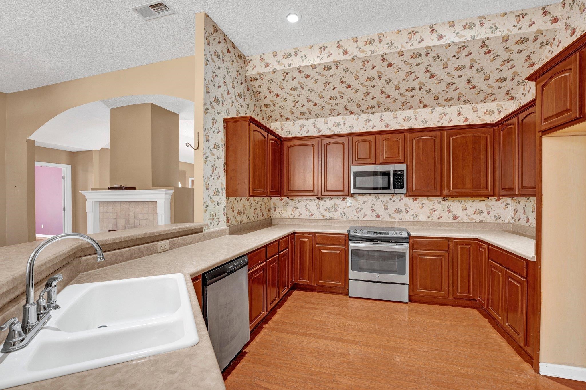 6150 Ricks Road Arlington, TN 38002 - Photo 13 of 40 Kitchen with a tile fireplace, sink, kitchen peninsula, light hardwood / wood-style floors, and appliances with stainless steel finishes