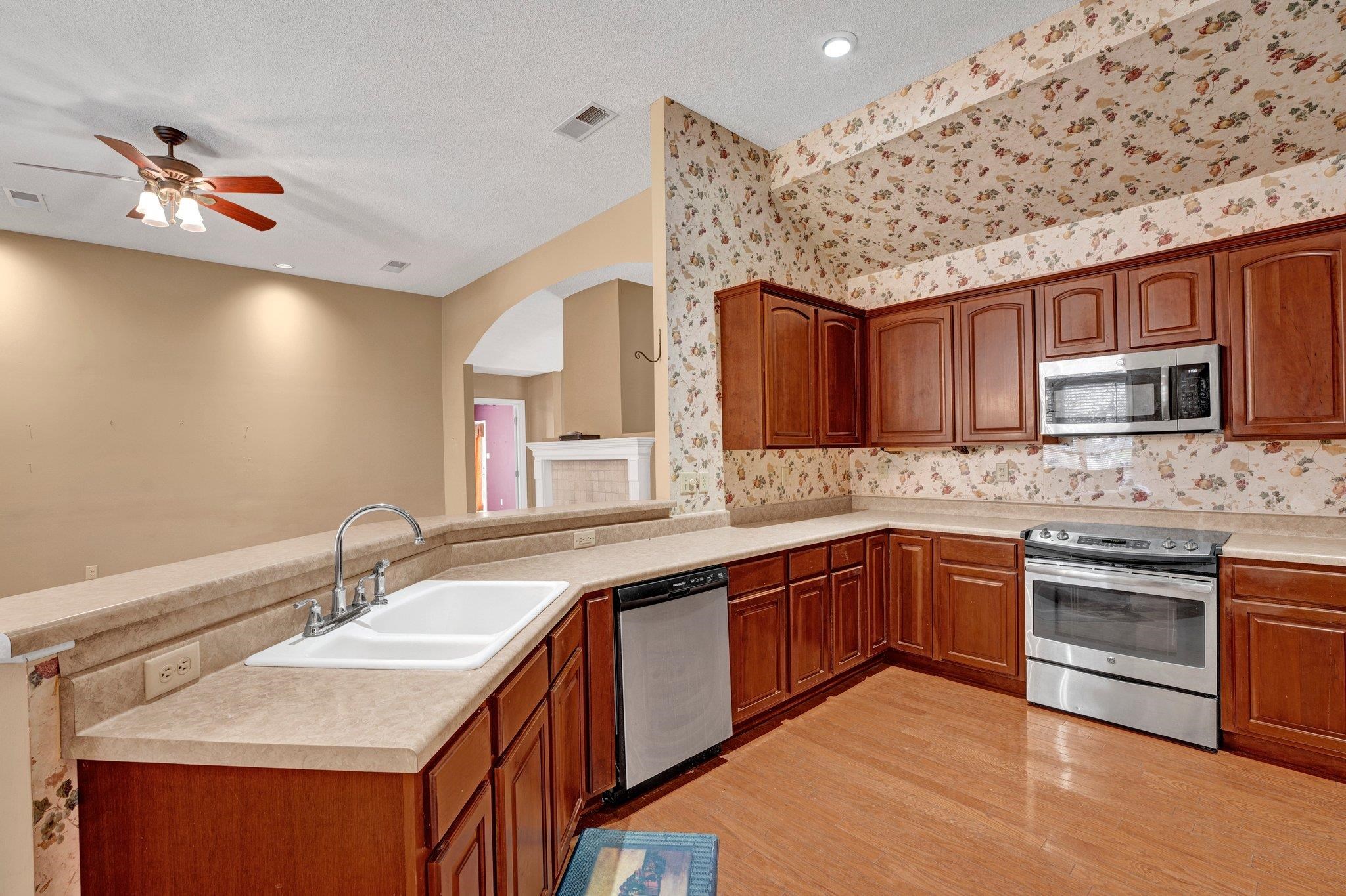 6150 Ricks Road Arlington, TN 38002 - Photo 14 of 40 Kitchen with kitchen peninsula, light wood-type flooring, stainless steel appliances, ceiling fan, and sink