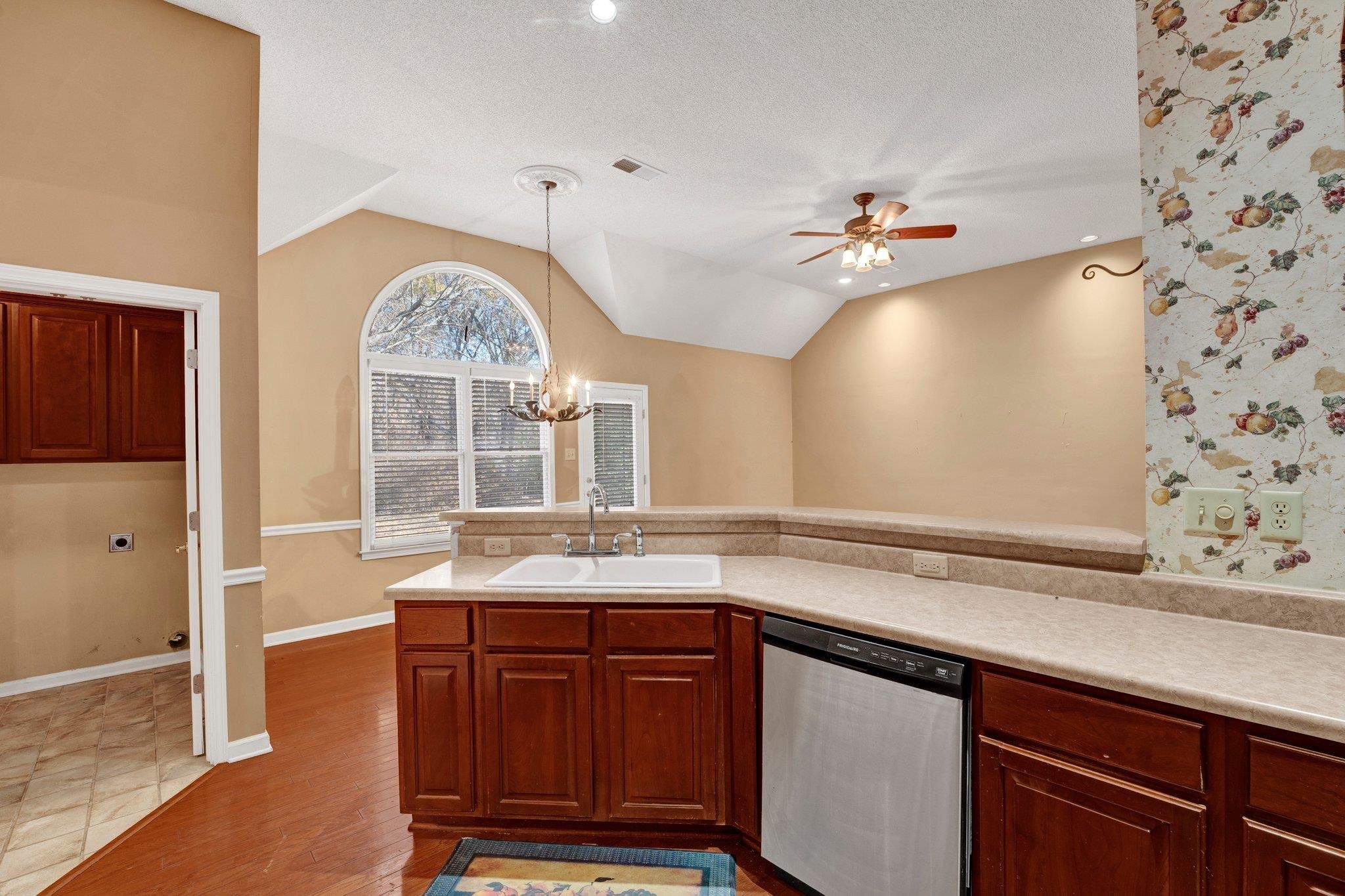 6150 Ricks Road Arlington, TN 38002 - Photo 16 of 40 Kitchen featuring dishwasher, sink, hardwood / wood-style floors, pendant lighting, and lofted ceiling