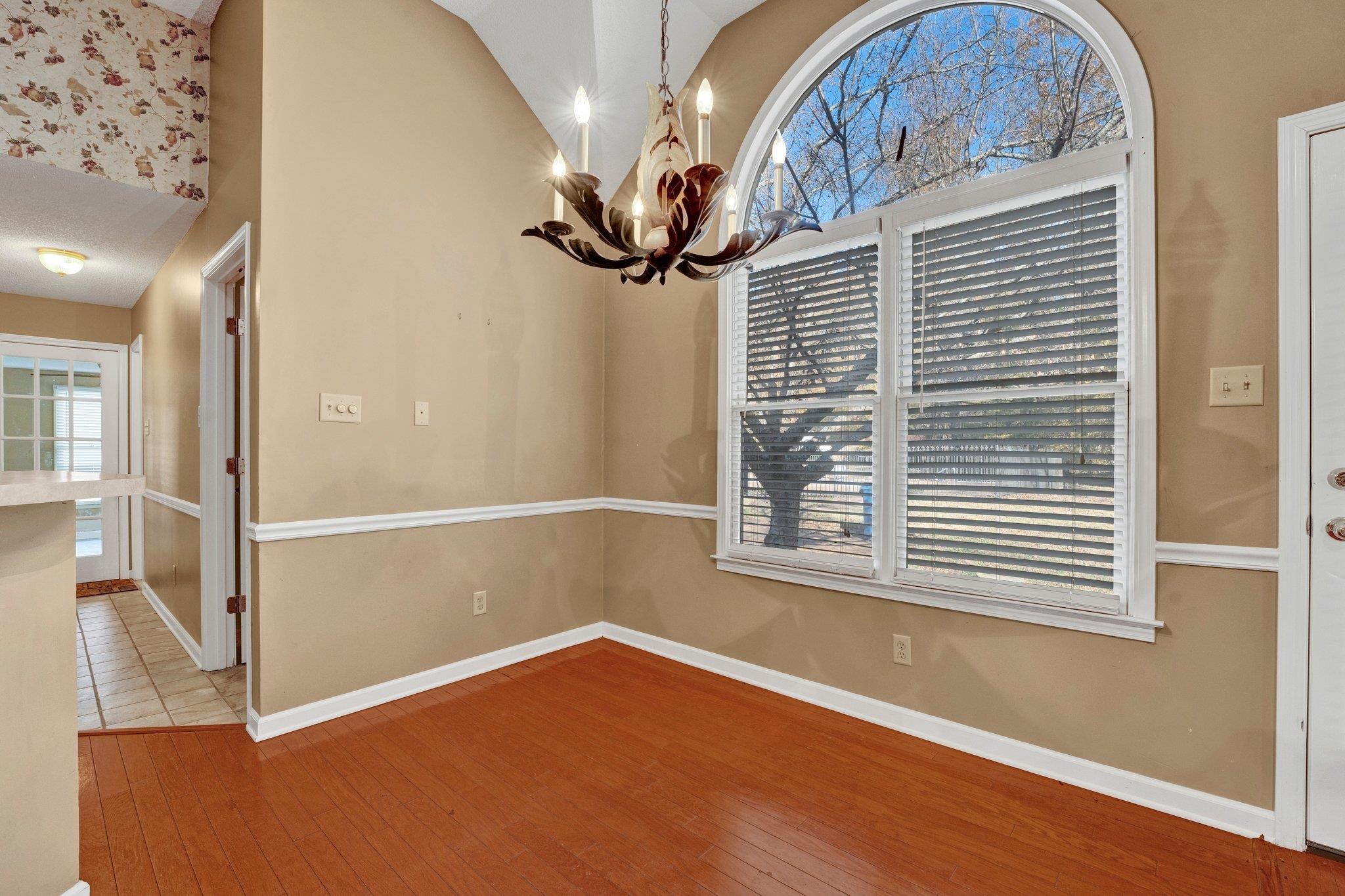 6150 Ricks Road Arlington, TN 38002 - Photo 21 of 40 Unfurnished dining area featuring lofted ceiling, wood-type flooring, and an inviting chandelier
