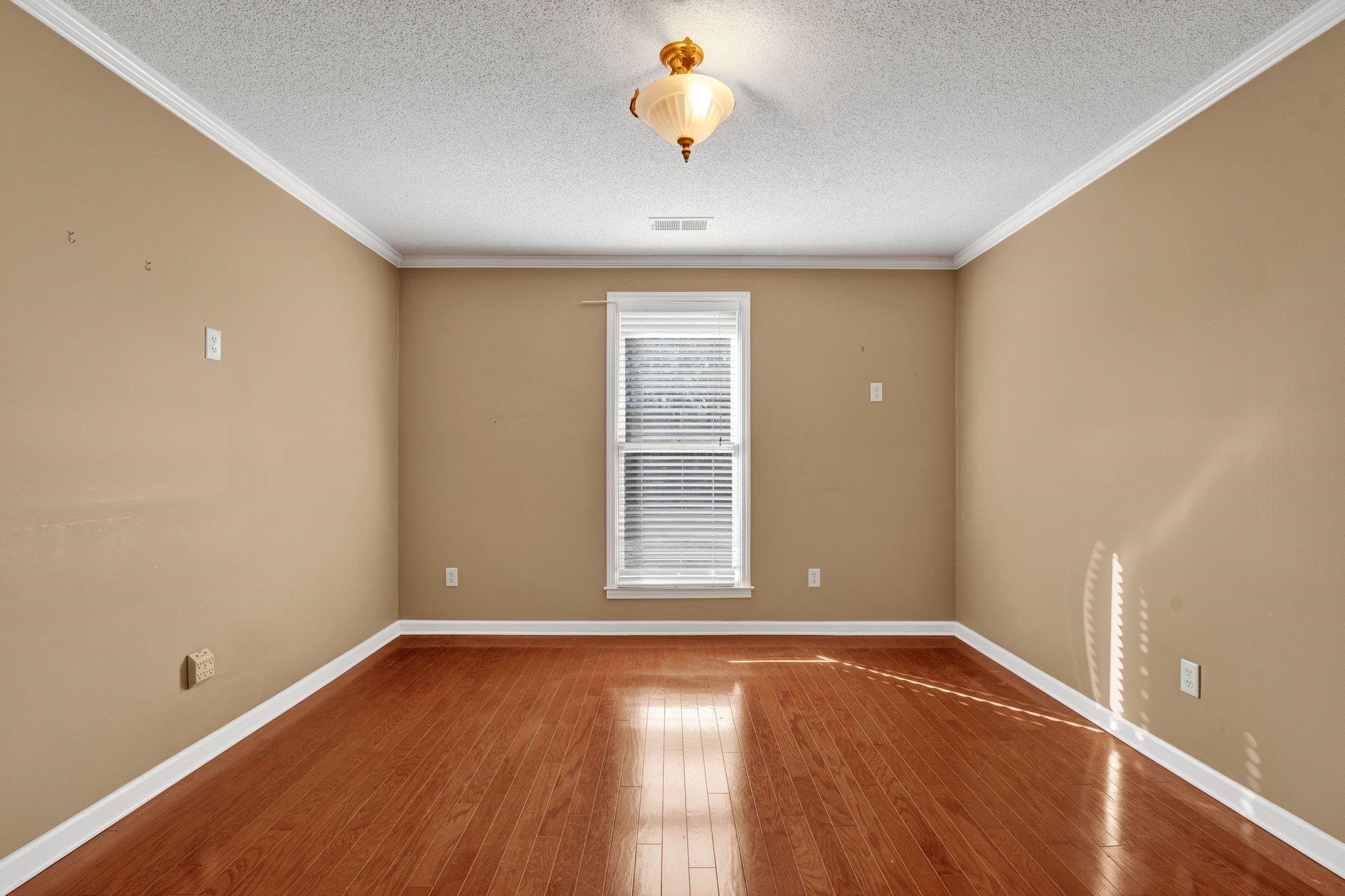 6150 Ricks Road Arlington, TN 38002 - Photo 30 of 40 Unfurnished room featuring a textured ceiling, hardwood / wood-style flooring, and crown molding