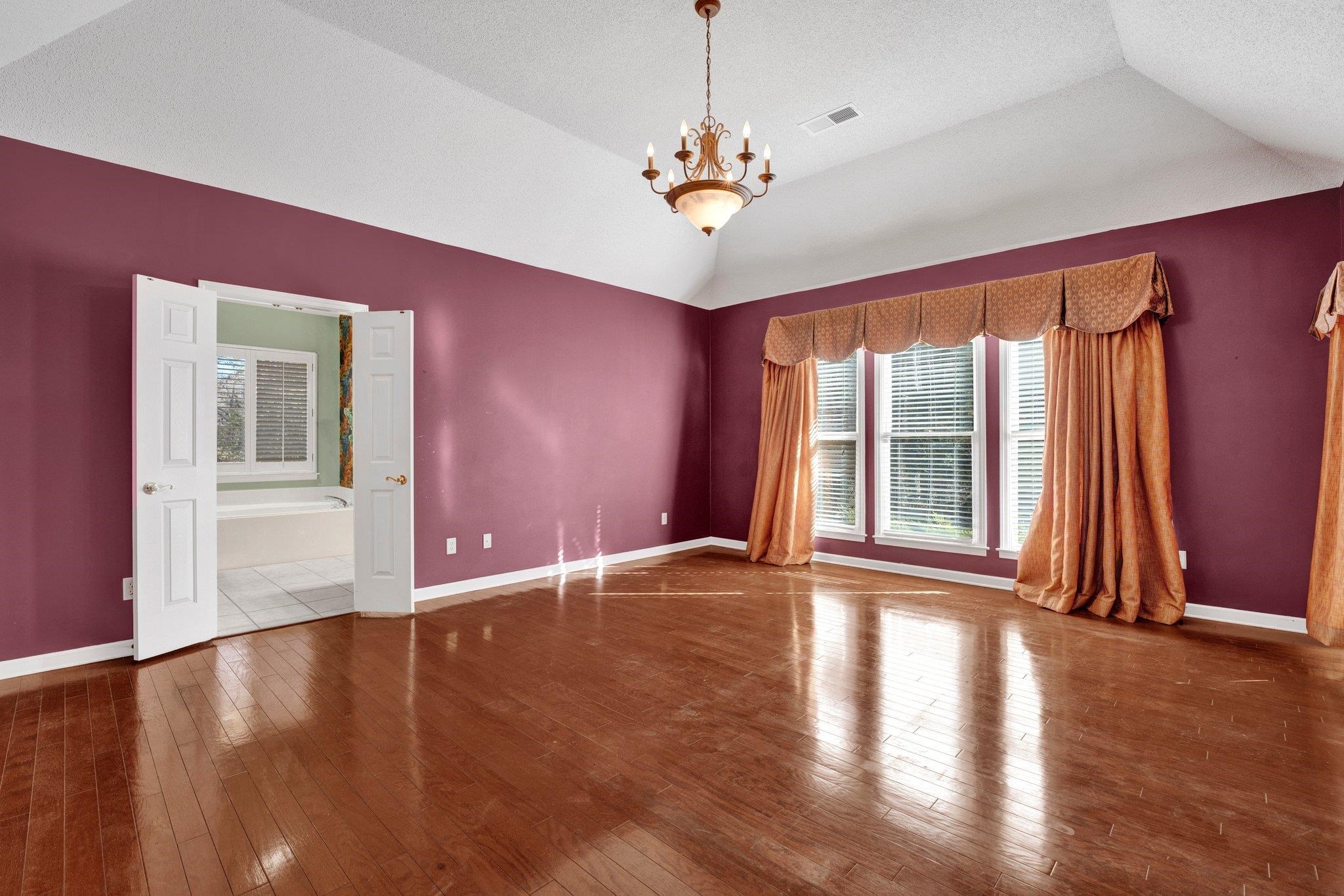 6150 Ricks Road Arlington, TN 38002 - Photo 33 of 40 Spare room with hardwood / wood-style flooring, a notable chandelier, a textured ceiling, and vaulted ceiling