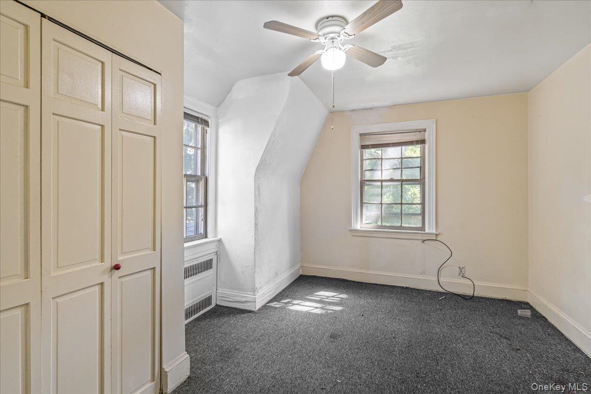 180-19 Grand Central Parkway Queens, NY 11432 - Photo 19 of 28 an empty room with windows and fan