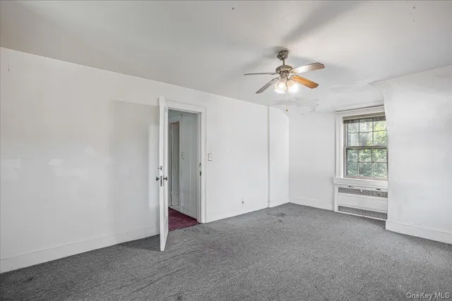 a view of a room with a ceiling fan and a window