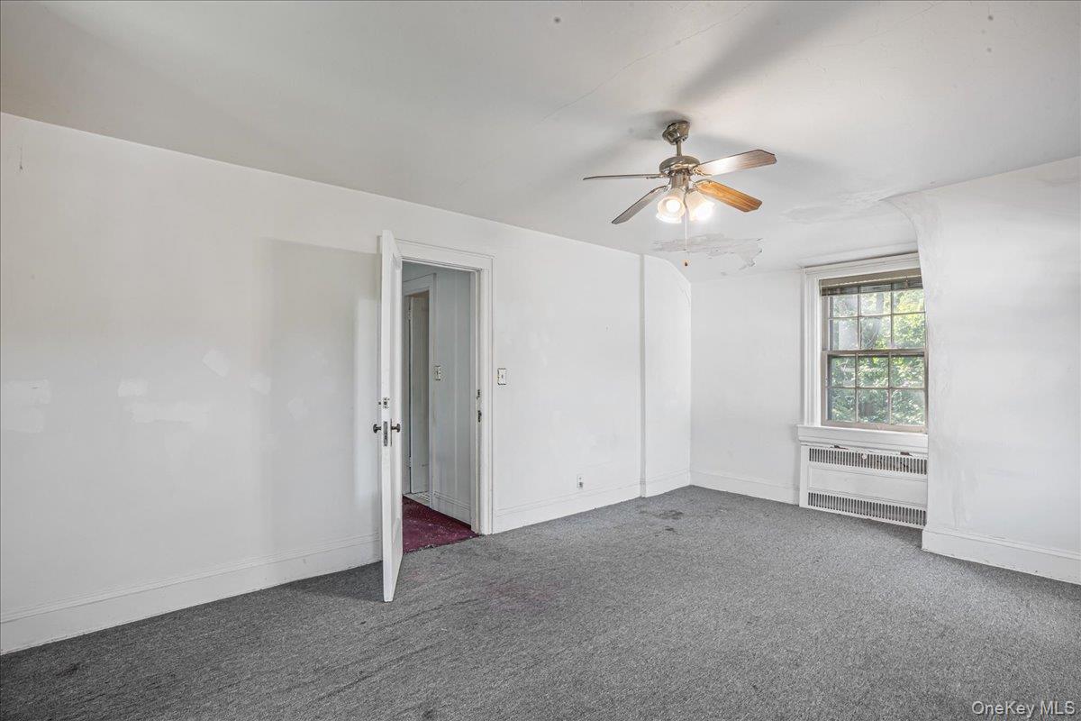 180-19 Grand Central Parkway Queens, NY 11432 - Photo 20 of 28 a view of a room with a ceiling fan and a window