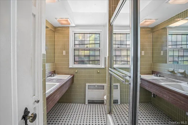 a bathroom with a sink a bathtub and next to a window