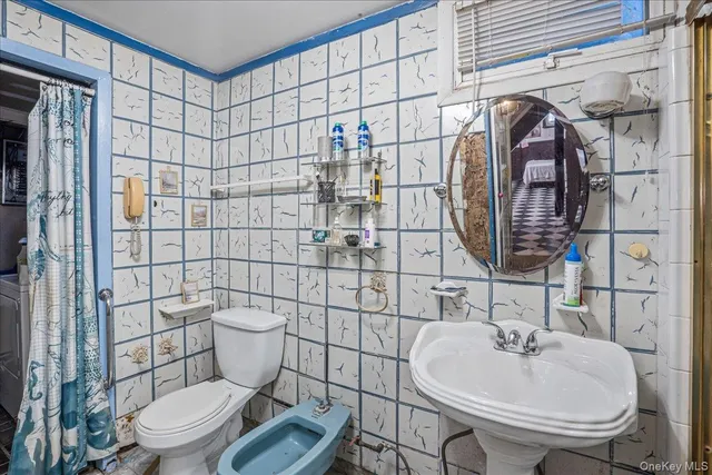 a bathroom with a toilet sink and mirror