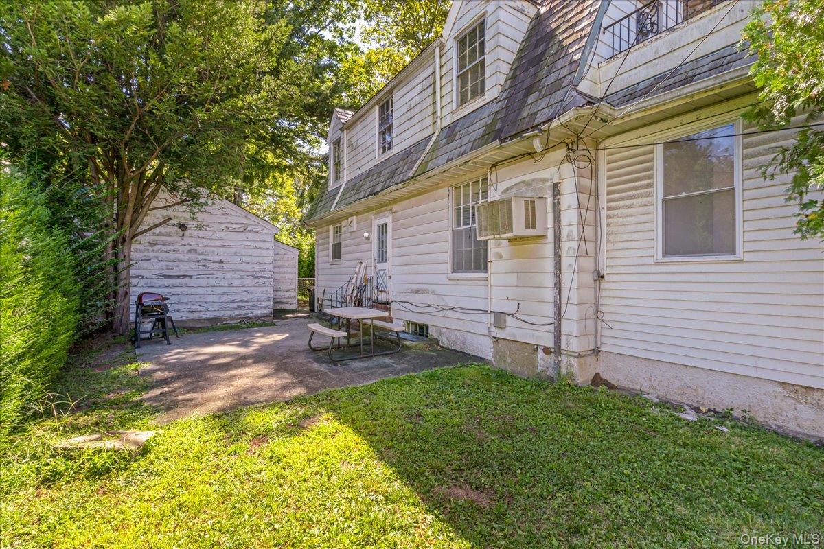 180-19 Grand Central Parkway Queens, NY 11432 - Photo 28 of 28 a view of a backyard with table and chairs and wooden fence