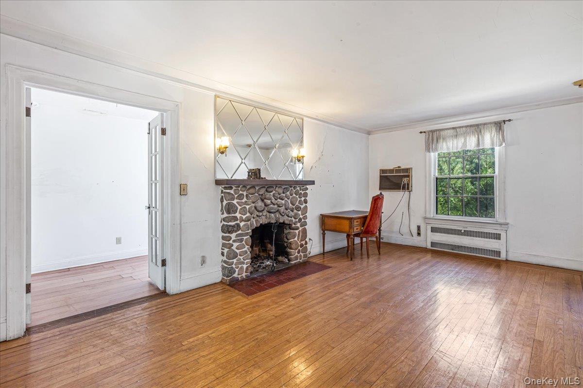 180-19 Grand Central Parkway Queens, NY 11432 - Photo 3 of 28 an empty room with furniture a fireplace and wooden floor
