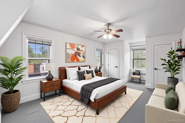 a bedroom with a large bed a potted plant and a window
