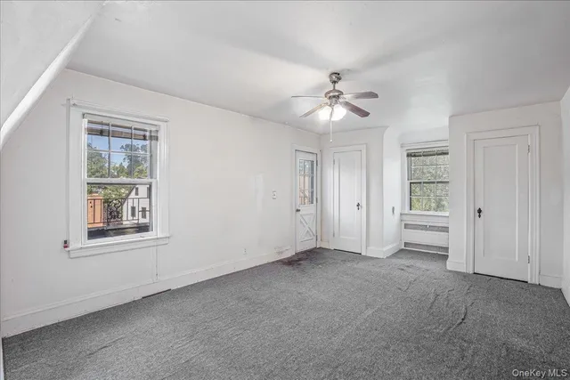 an empty room with windows and closet