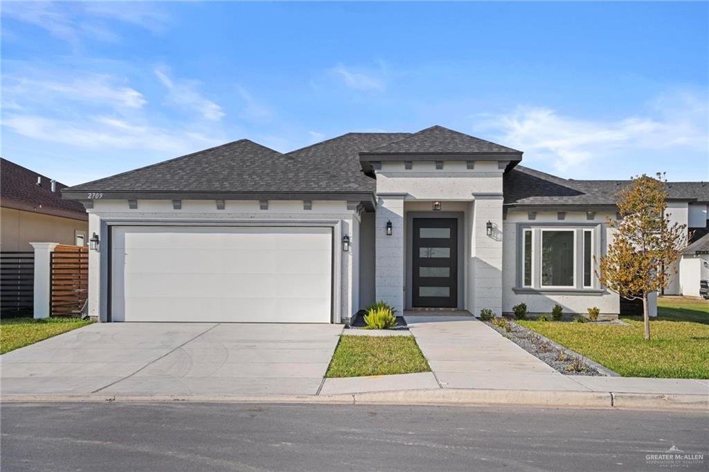 2709 East Conroe Road Edinburg, TX 78542 - Photo 1 of 1 View of front of house with a shingled roof, concrete driveway, and a garage