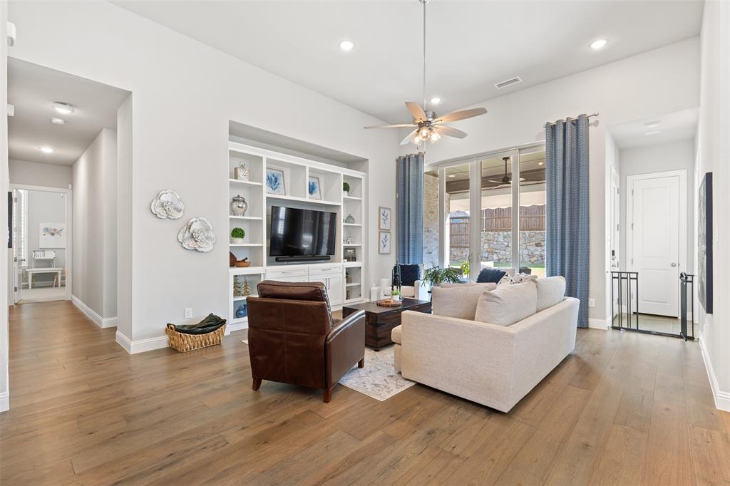 9716 Wilderness Road Little Elm, TX 75068 - Photo 15 of 39 Living room with integrated built-in cabinetry, wood-finish flooring, recessed lighting, and large sliding glass doors