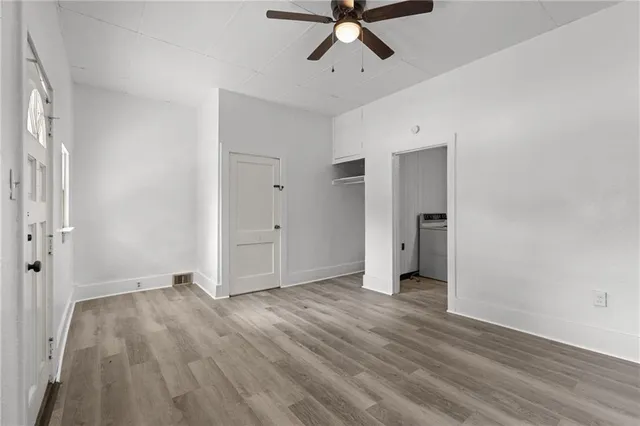 a view of a room with wooden floor and white walls