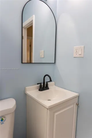 a bathroom with a toilet sink and mirror