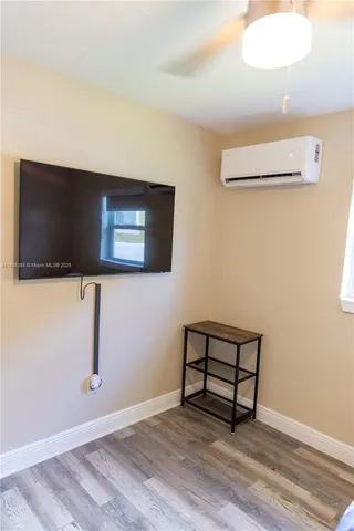 a view of a livingroom with wooden floor and a flat screen tv