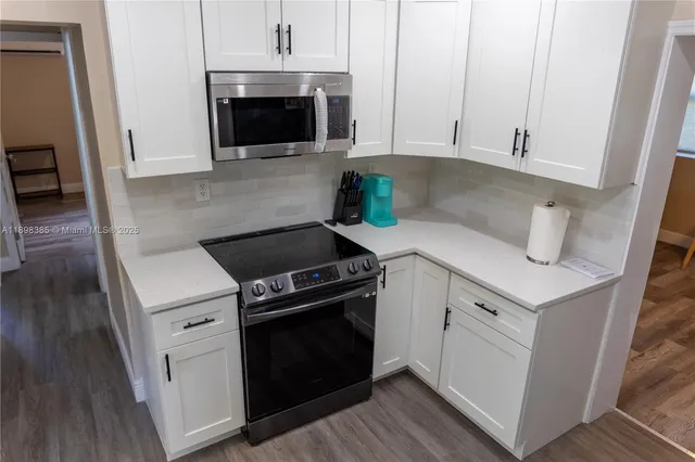 a kitchen with white cabinets and white appliances