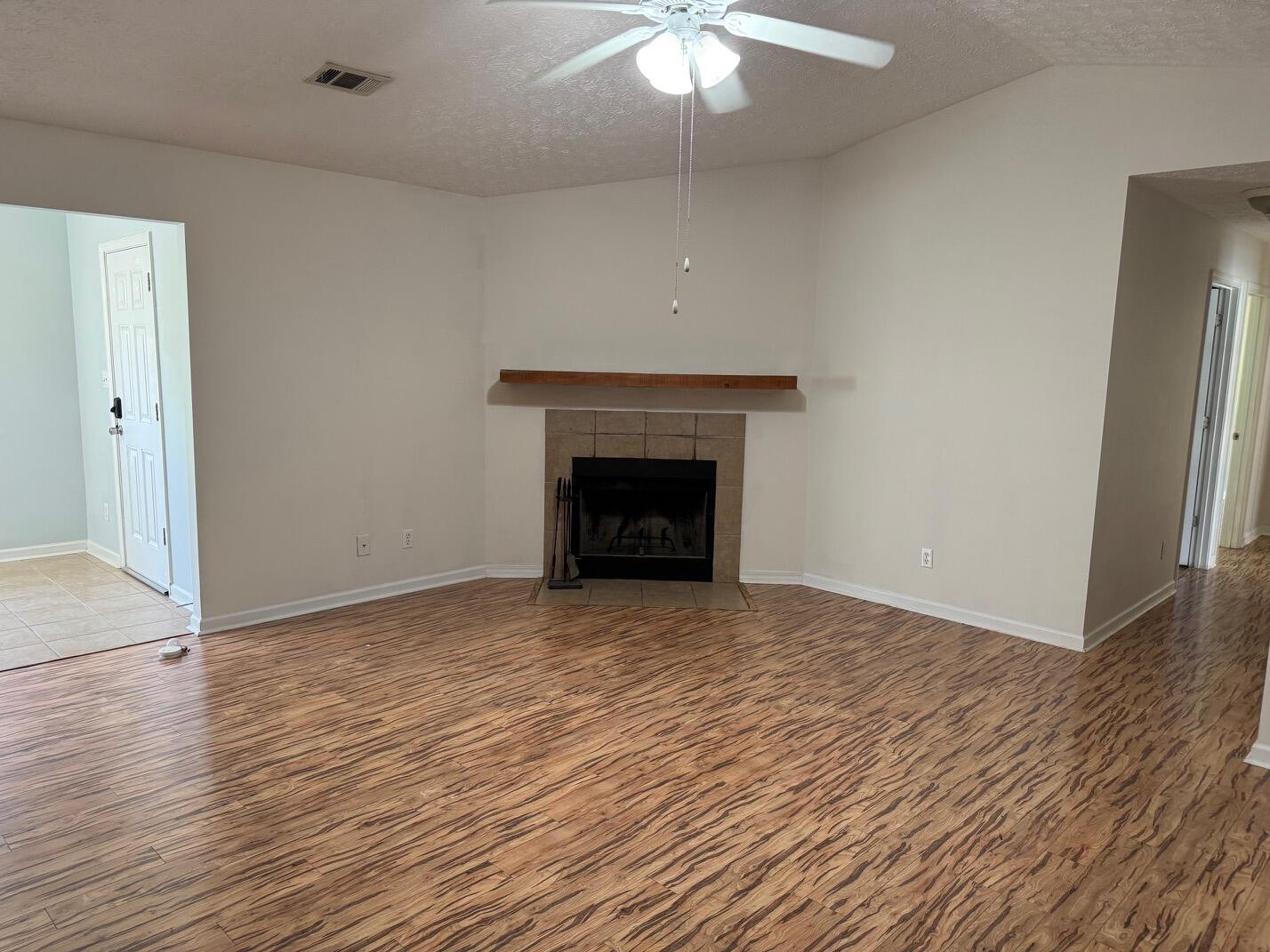 225 Bay Grove Road Freeport, FL 32439 - Photo 23 of 33 wooden floor fireplace and natural light in room
