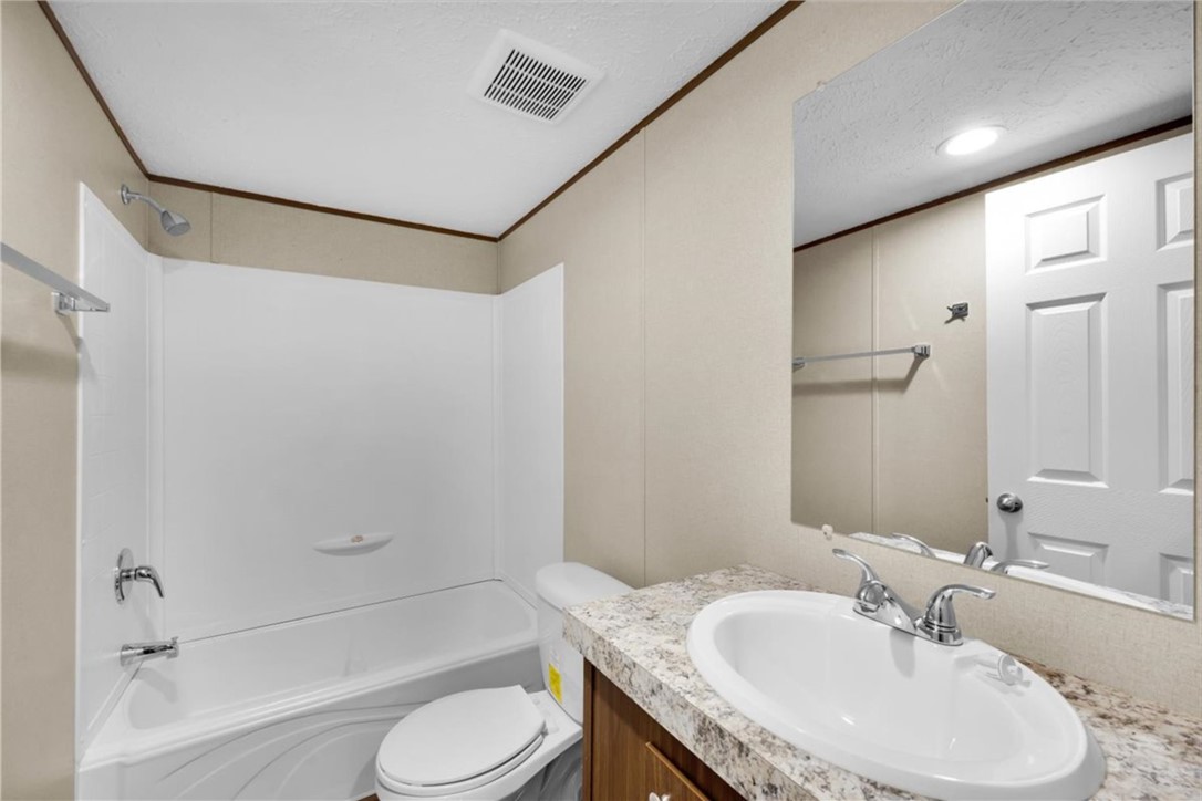 2919 High Shoals Road Anderson, SC 29624 - Photo 15 of 21 This bright bathroom features a vanity with a clean white sink, a mirror, and a classic shower-tub combo.