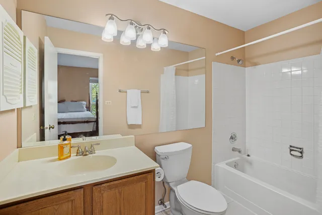 a bathroom with a granite countertop sink toilet a large mirror and shower