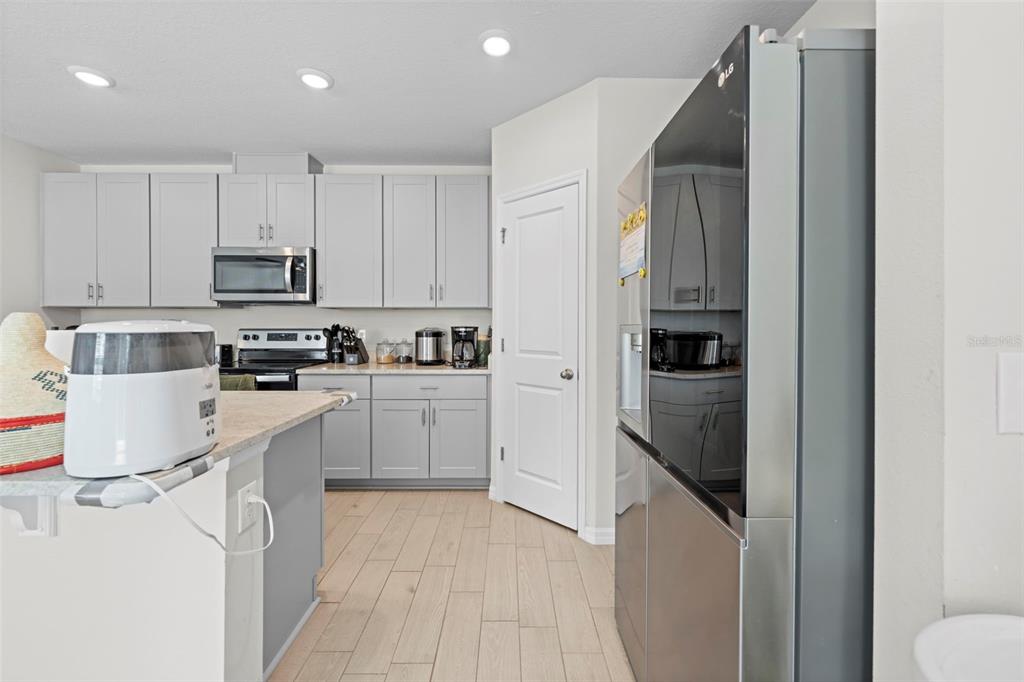 12354 Huron Street Spring Hill, FL 34609 - Photo 12 of 48 a kitchen with white cabinets and stainless steel appliances