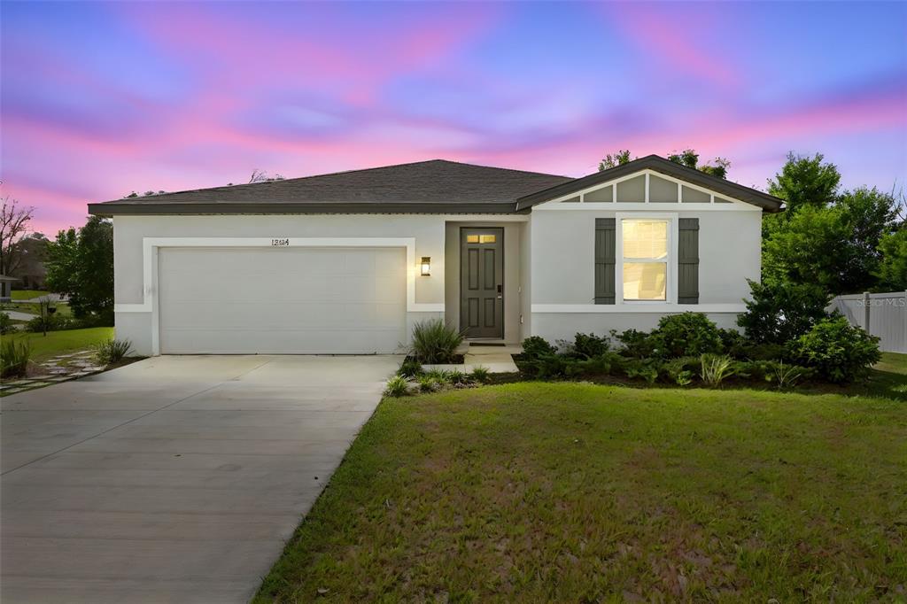12354 Huron Street Spring Hill, FL 34609 - Photo 2 of 48 a front view of a house with a yard and garage