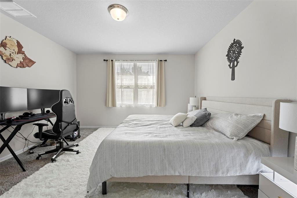 12354 Huron Street Spring Hill, FL 34609 - Photo 21 of 48 a bedroom with a bed a desk and chair with window