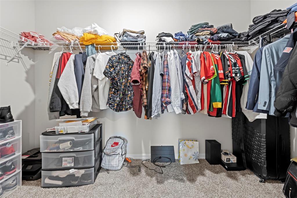 12354 Huron Street Spring Hill, FL 34609 - Photo 26 of 48 a view of walk in closet with clothes and shoes