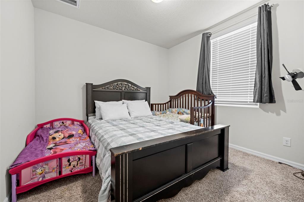 12354 Huron Street Spring Hill, FL 34609 - Photo 36 of 48 a bedroom with a bed and a dresser