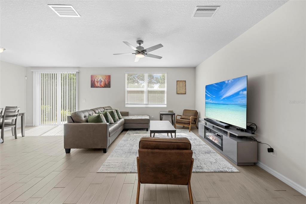 12354 Huron Street Spring Hill, FL 34609 - Photo 6 of 48 a living room with furniture workspace and a flat screen tv