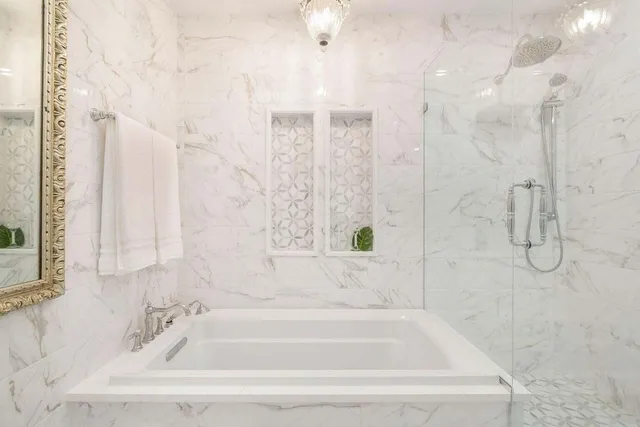 a white bath tub sitting next to a shower