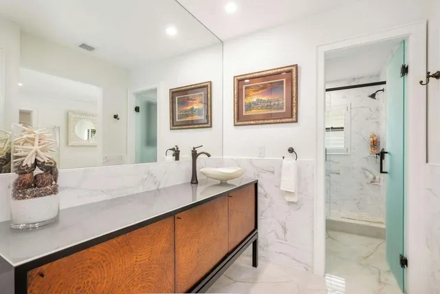 a en suite bathroom with a granite countertop sink and a shower