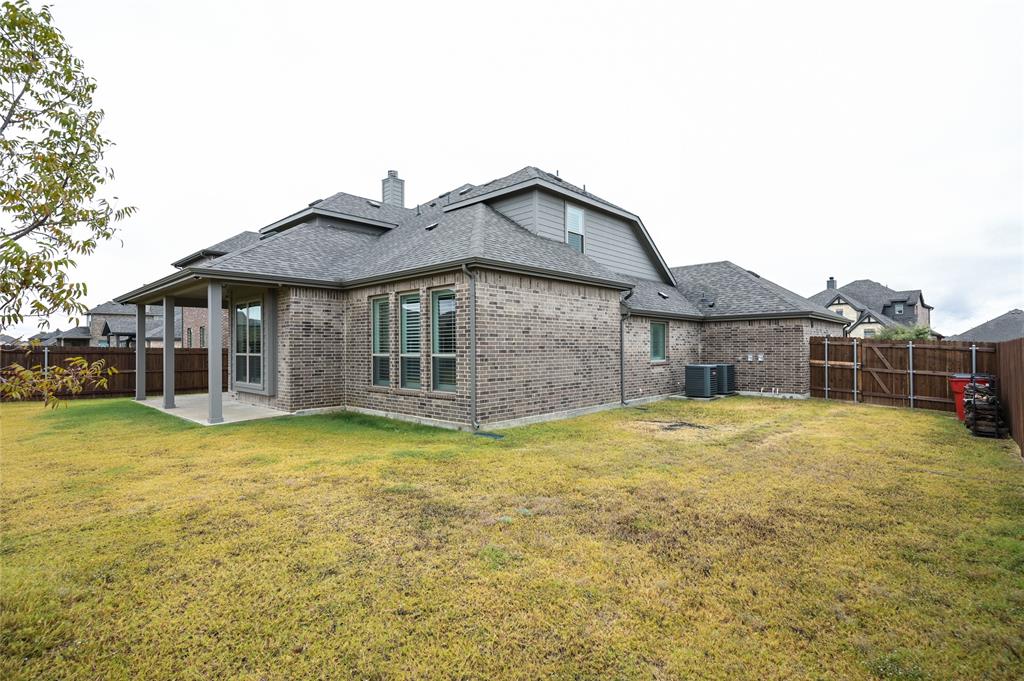 809 Deleon Drive Midlothian, TX 76065 - Photo 30 of 30 Rear view of house with a fenced backyard, brick siding, a patio area, and roof with shingles