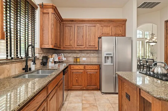 a kitchen with stainless steel appliances granite countertop a refrigerator sink and cabinets